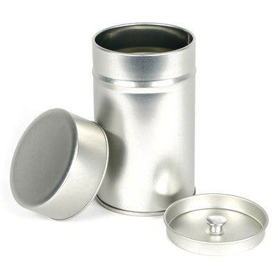 petite boîte à thé cylindrique nue en métal debout et ouverte