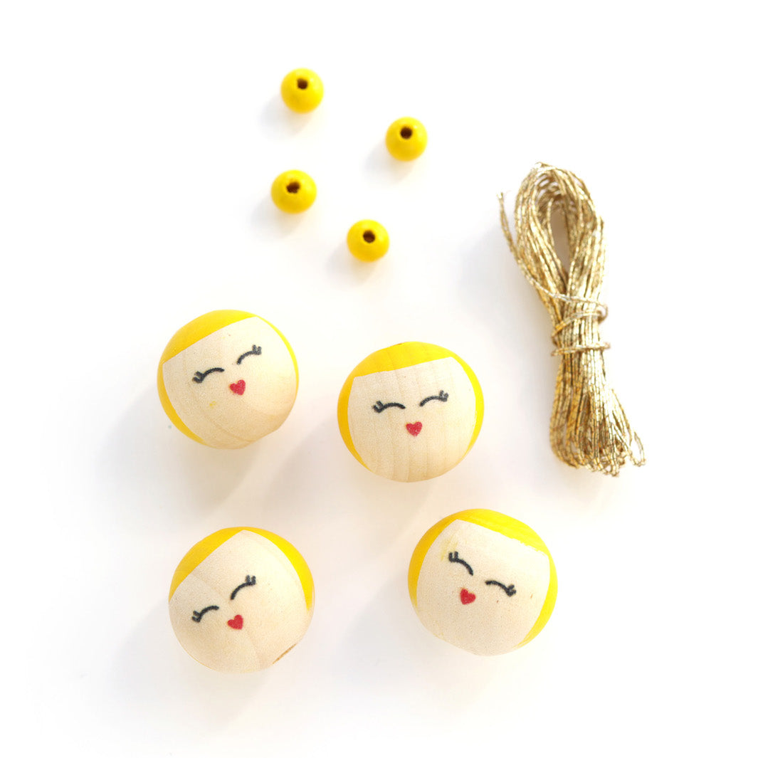 petites perles roses, perles « visages » souriants aux détails jaunes et fil doré