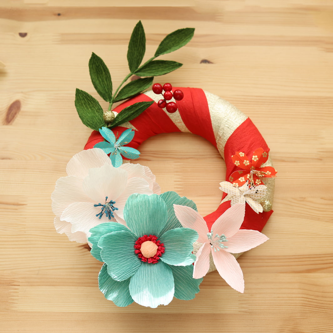 photo d'ambiance de la couronne de Noël de l'atelier couronne de Noël avec des fleurs en papier crépon