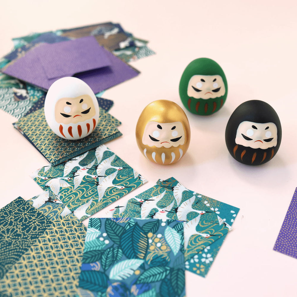 photo d'ambiance de daruma en céramique blancs, dorés, verts et noirs