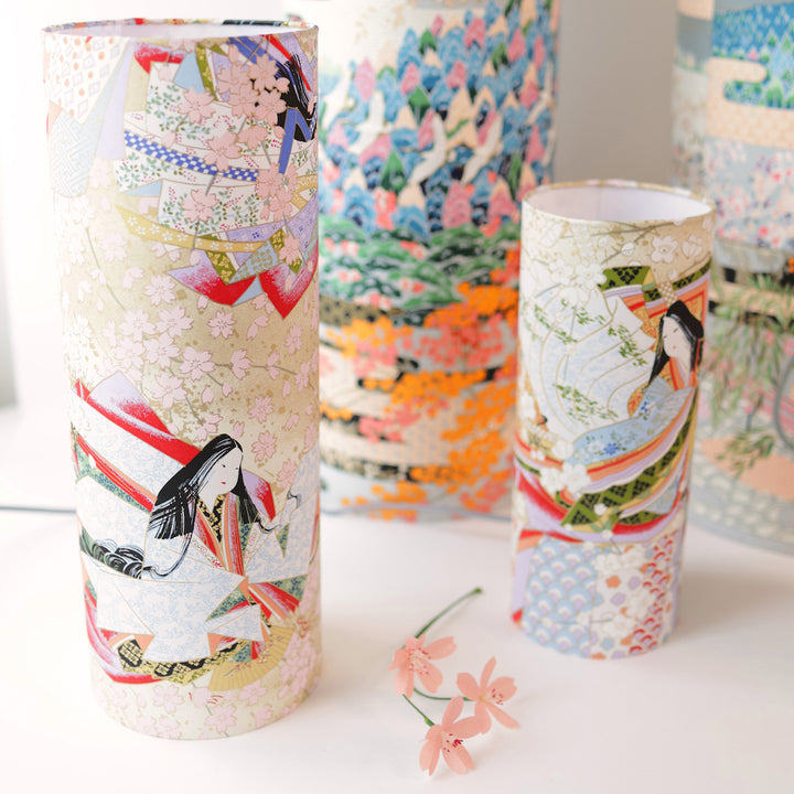 photo d'ambiance avec une vue de face en biais de lampes à poser japonaise (taille s et m) au motif de femmes en kimono dans les tons mordorés, rouges, verts, bleus et mauves