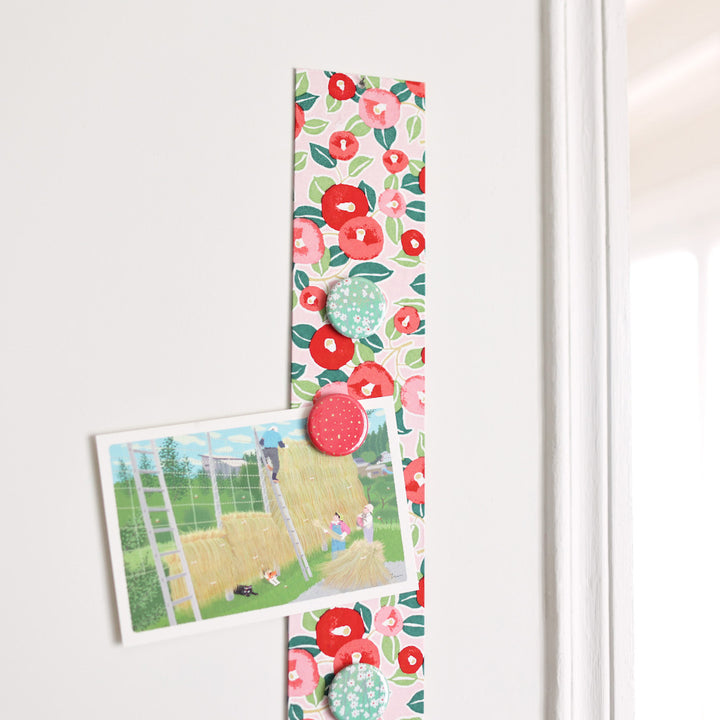 photo d'ambiance avec une vue zoomée du pêle-mêle tapissé du papier japonais aux motifs de camélias dans les tons rouges, roses et verts M722 adeline klam