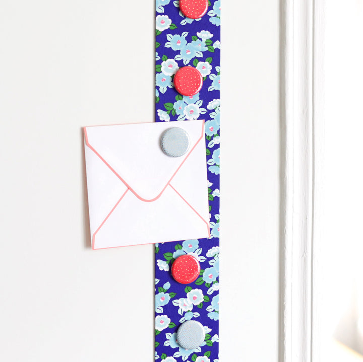 photo d'ambiance avec une vue zoomée du pêle-mêle tapissé du papier japonais aux motifs de camélias dans les tons bleus, violets et verts M955 adeline klam