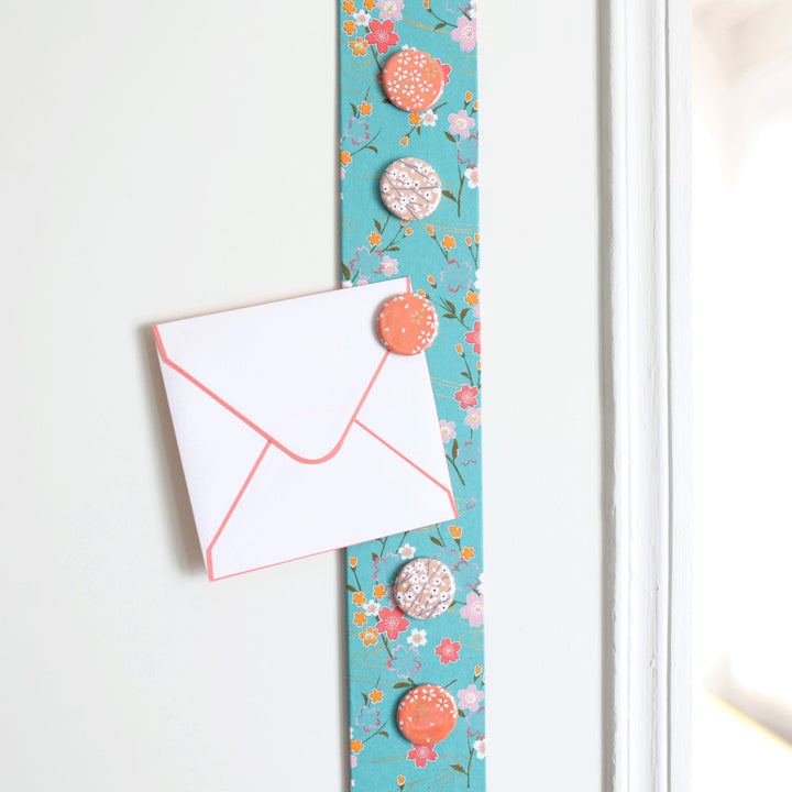 photo d'ambiance avec une vue zoomée du pêle-mêle tapissé du papier japonais aux motifs fleuris turquoise M380 adeline klam