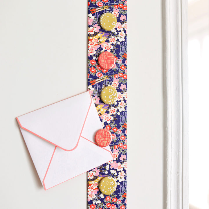 photo d'ambiance avec une vue zoomée du pêle-mêle tapissé du papier japonais aux motifs de fleurs de cerisier, de chrysanthèmes, de glycines et d'éventails dans les tons violets, roses, blancs et rouges M908 adeline klam