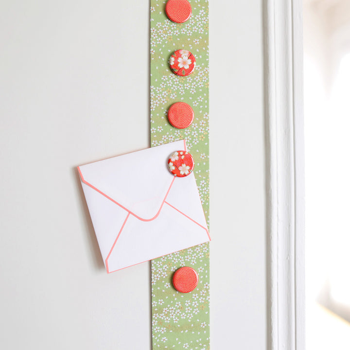 photo d'ambiance avec une vue zoomée du pêle-mêle tapissé du papier japonais aux motifs de fleurs au vent vert amande M984 adeline klam