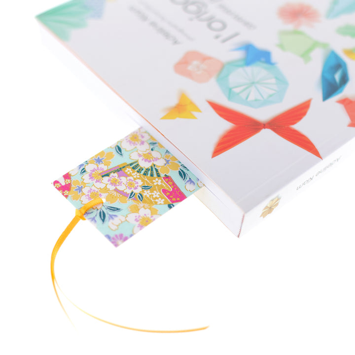 photo de mise en situation du marque-page en papier japonais aux motifs de glycines, de fleurs de cerisier et de kanoko dans les tons vert d'eau, parme et jaune moutarde (M1017 et M603) adeline klam