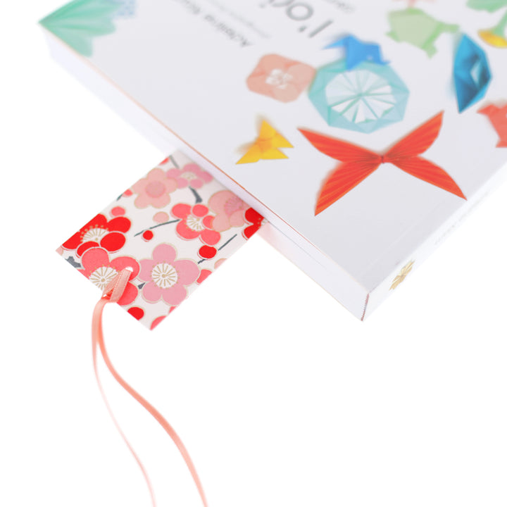 photo de mise en situation du marque-page en papier japonais aux motifs de grandes fleurs de prunier et de semi de fleurs dans les tons rouges, roses, beige, blancs et gris (M451 et M532) adeline klam