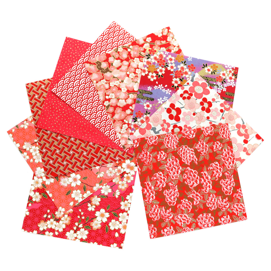 photo packshot de l'assortiment de papiers japonais du set de 7 carrés de papiers japonais adeline klam de 12cm par 12cm dans les tons rouges, rouge orangé et roses « grenadine »