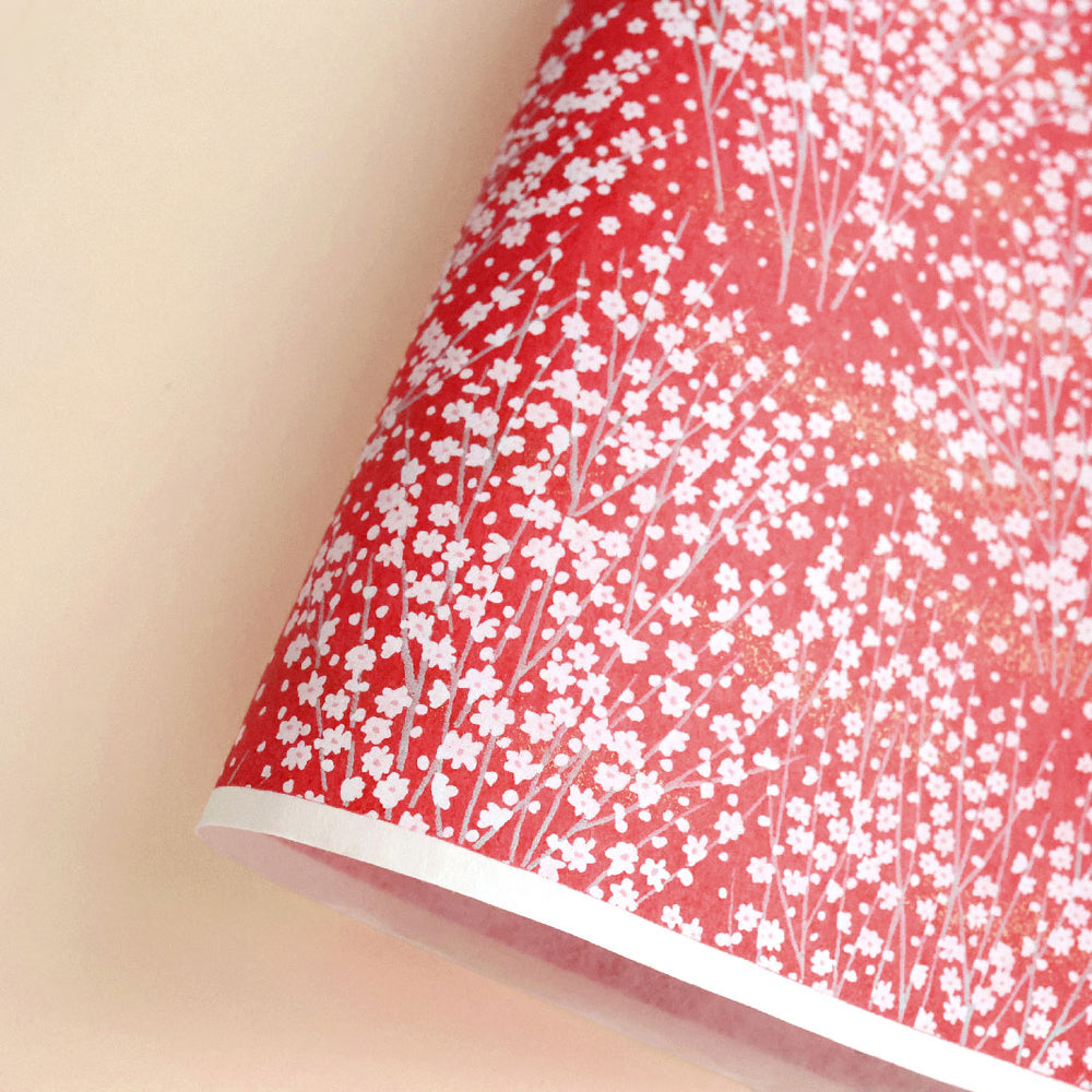 photo packshot d'une courbe de papier japonais yuzen chiyogami aux motifs de champs de fleurs dans les tons rouges (M813)