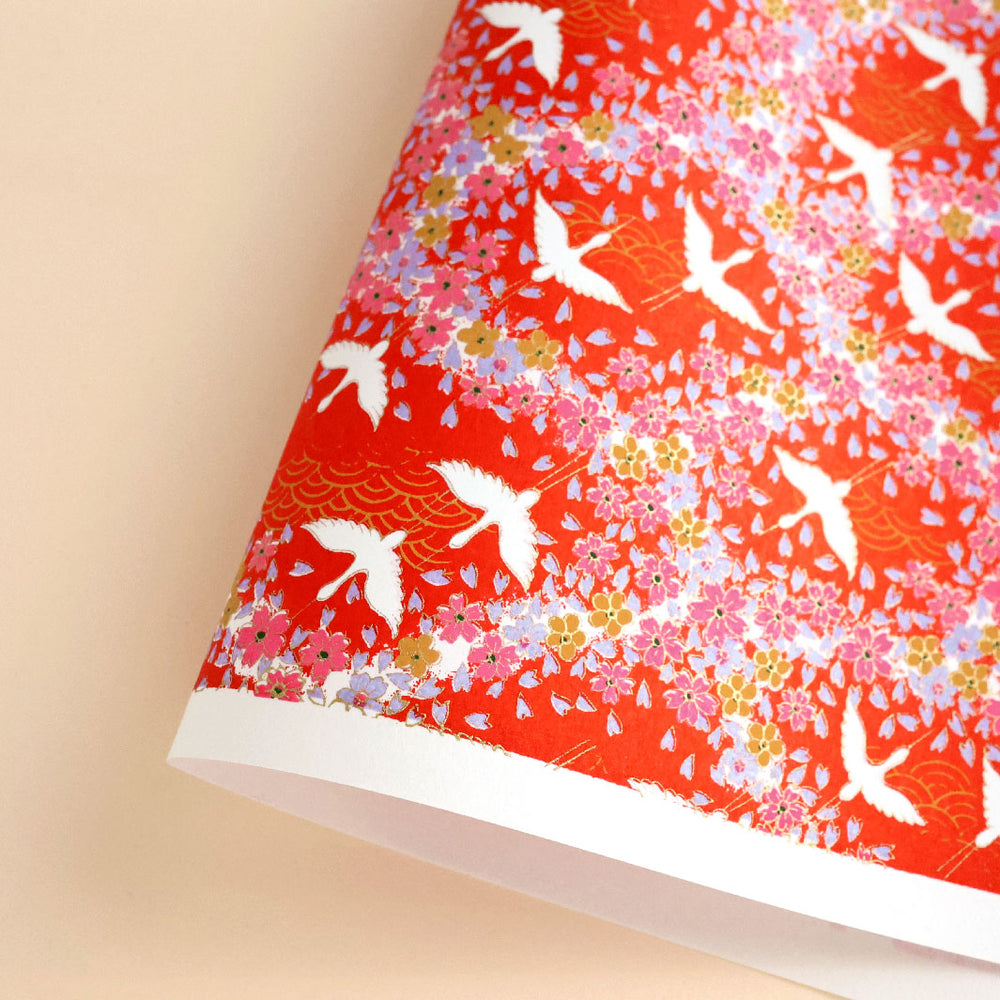photo packshot d'une courbe de papier japonais yuzen chiyogami aux motifs d'envolée de grues et de nuée de fleurs dans les tons rouges adeline klam (M322)