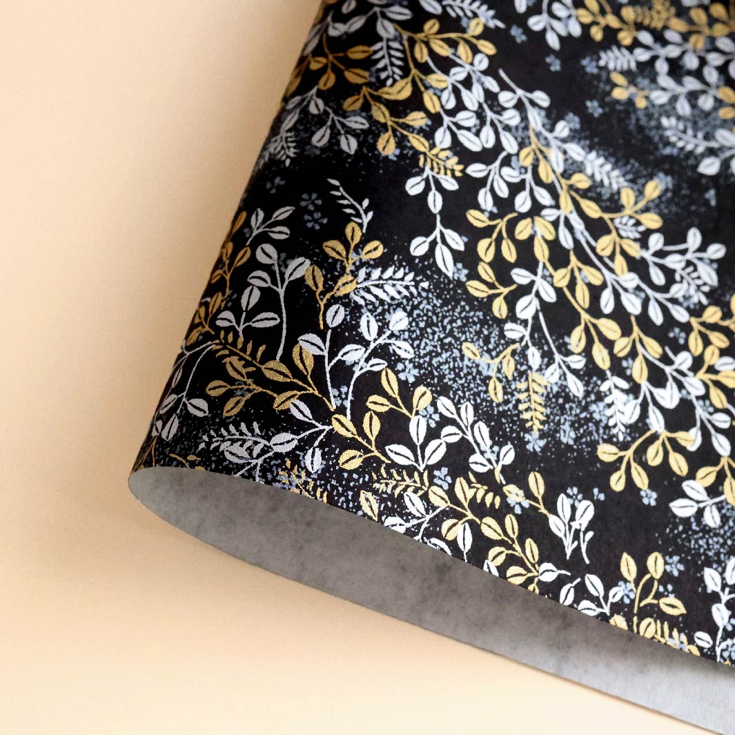 photo packshot d'une courbe de papier japonais yuzen chiyogami aux motifs de feuillages variés dans les tons noirs, dorés et argentés adeline klam (M979)