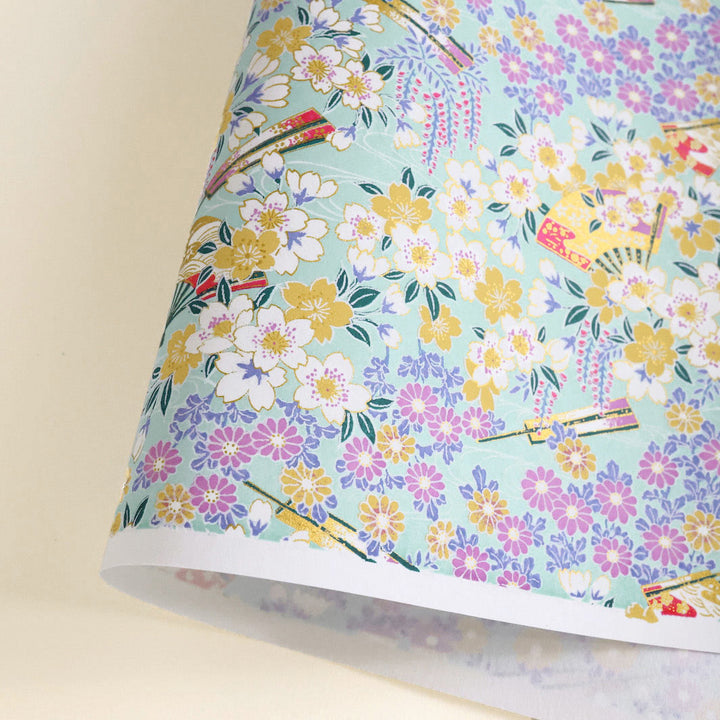 photo packshot d'une courbe de papier japonais yuzen chiyogami aux motifs de fleurs de cerisier, de chrysanthèmes, de glycines et d'éventails dans les tons vert d'eau, jaunes, mauve, parme et blancs adeline klam M1017