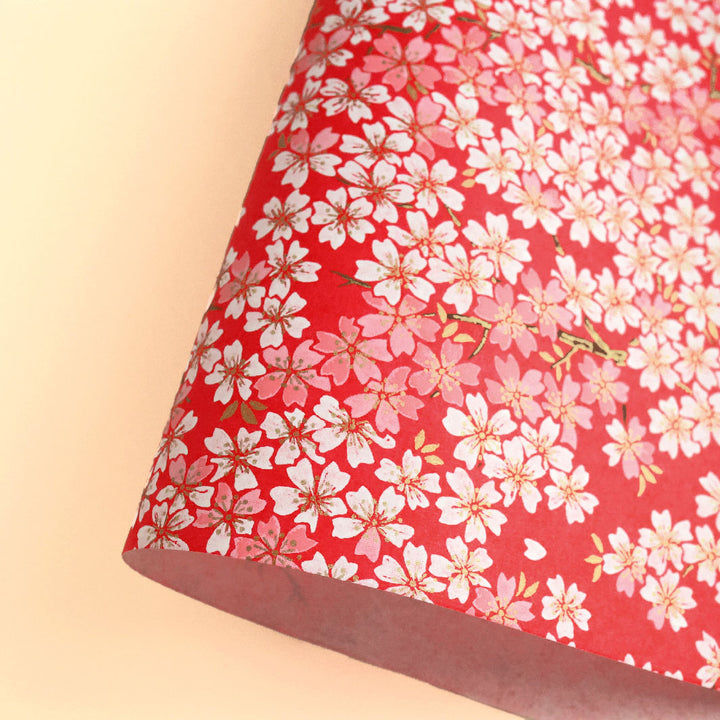 photo packshot d'une courbe de papier japonais yuzen chiyogami aux motifs de fleurs de cerisier dans les tons rouges, roses et blancs adeline klam (M623)