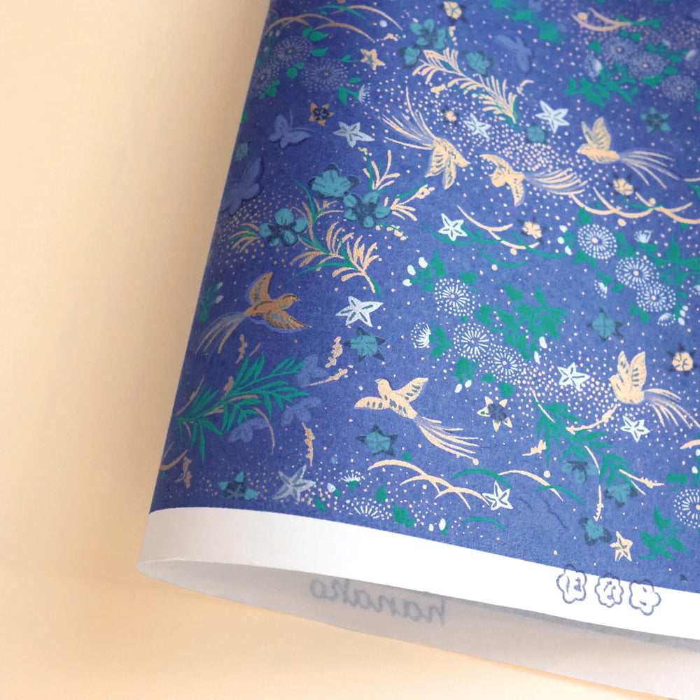 photo packshot d'une courbe du papier japonais yuzen chiyogami aux motifs de fleurs, d'oiseaux et de papillons dans les tons bleu foncé, verts, mauven argentés et dorés adeline klam (M992)