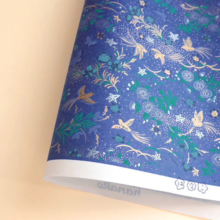photo packshot d'une courbe du papier japonais yuzen chiyogami aux motifs de fleurs, d'oiseaux et de papillons dans les tons bleu foncé, verts, mauven argentés et dorés adeline klam (M992)