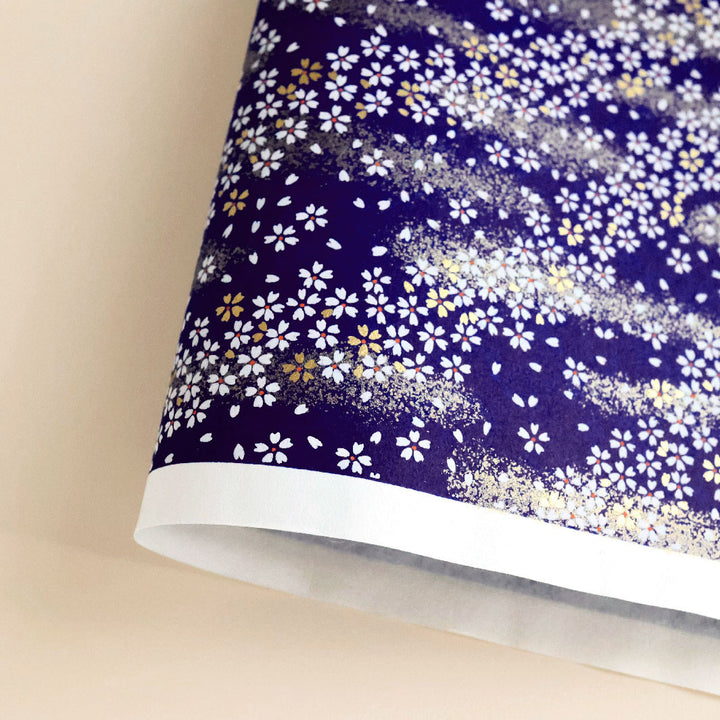 photo packshot d'une courbe de papier japonais yuzen chiyogami aux motifs de fleurs au vent dans les tons bleu nuit (M759)
