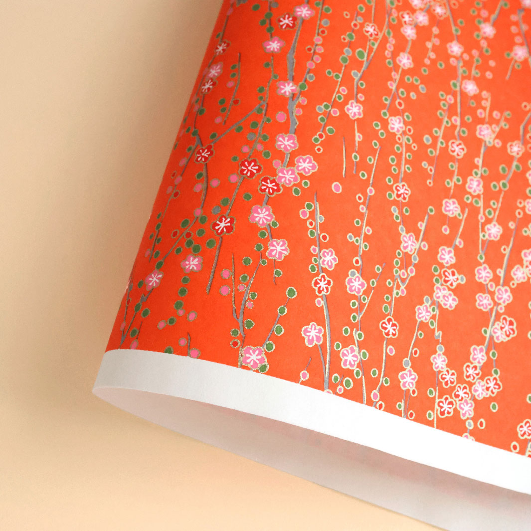 photo packshot d'une courbe de papier japonais yuzen chiyogami aux motifs branches en fleurs dans les rouge orange, roses et verts adeline klam (M427)