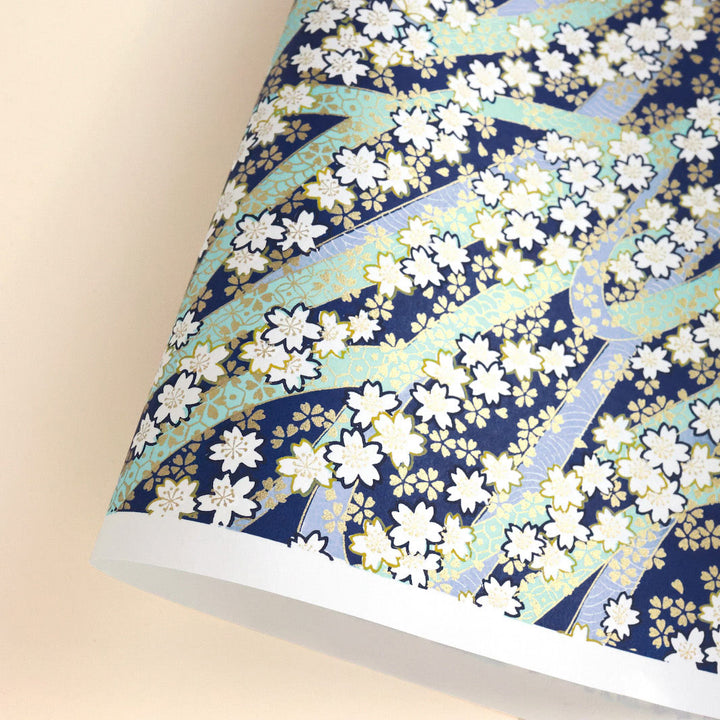 photo packshot d'une courbe de papier japonais yuzen chiyogami aux motifs d'ondulations fleuries dans les tons bleu marine, bleu mauve, vert d'eau, jaune moutarde et dorés adeline klam M999