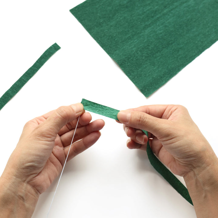 photo packshot de démonstration de l'étape 1 de d'habillage de tiges avec du papier crépon (561) pour le kits bouquet de fleurs en crépon « tutti frutti » et « amour » adeline klam