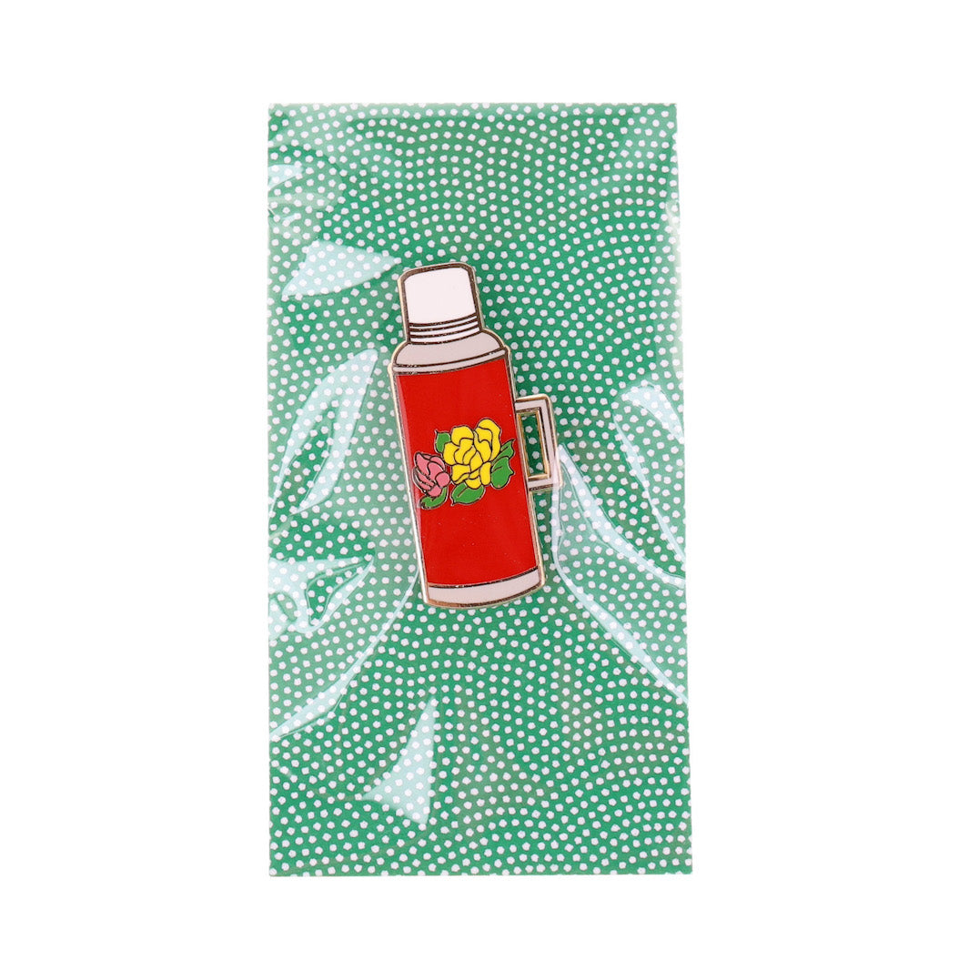 photo packshot du packaging du pin's en forme de thermos fleuri rouge, blanc, jaune et rose