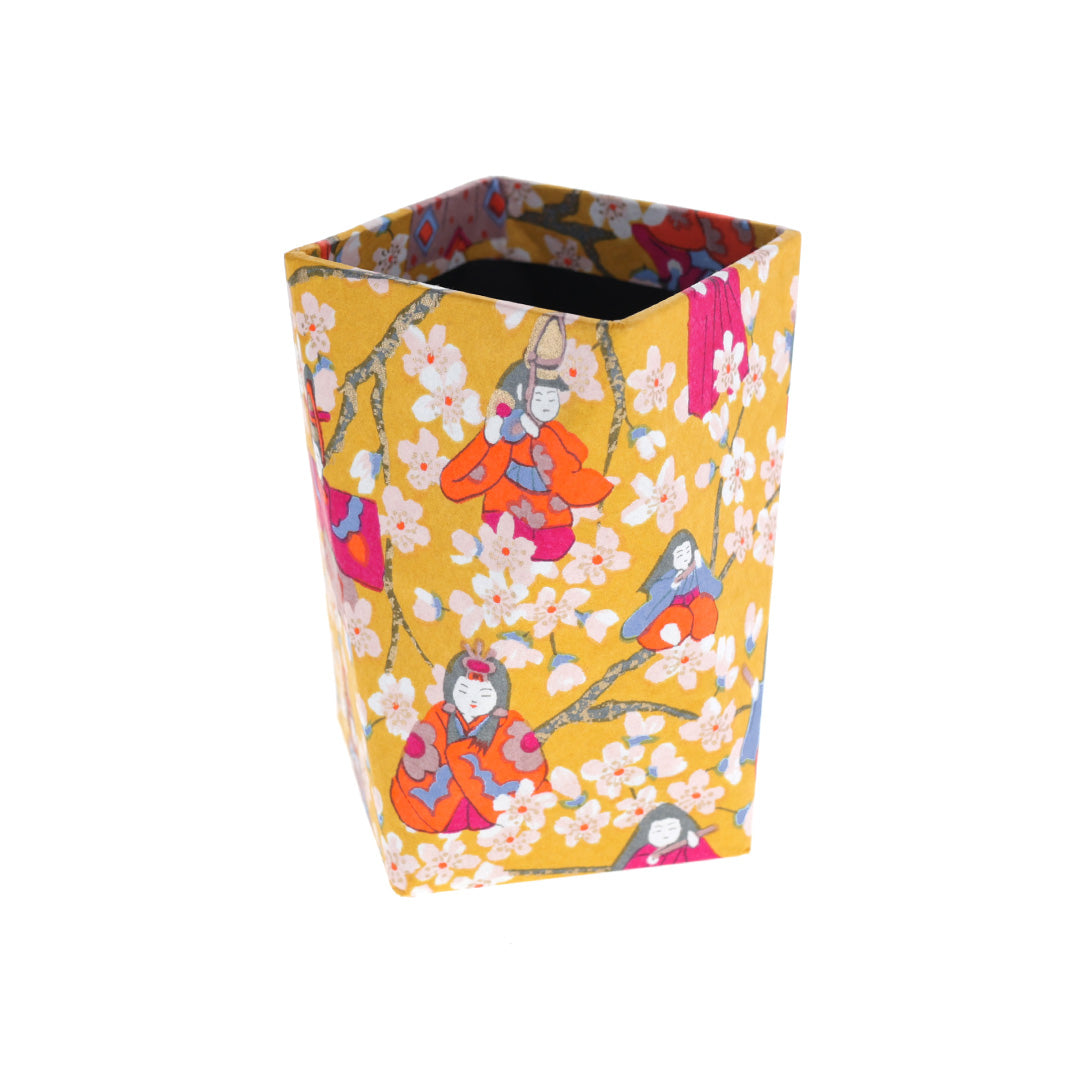 photo packshot du pot à crayon prisme au motifs de poupées d'hina matsuri et de fleurs de pêcher dans les tons jaune moutarde, orange vif, rose fuschia, bleu clair et lie de vin adeline klam (M1006)