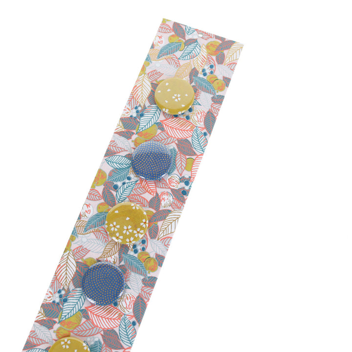 photo packshot avec une vue de biais du pêle-mêle tapissé du papier japonais aux motifs de feuilles, de baies et de fruits dans les tons rose pâle, bleu gris et jaune coing M896 adeline klam