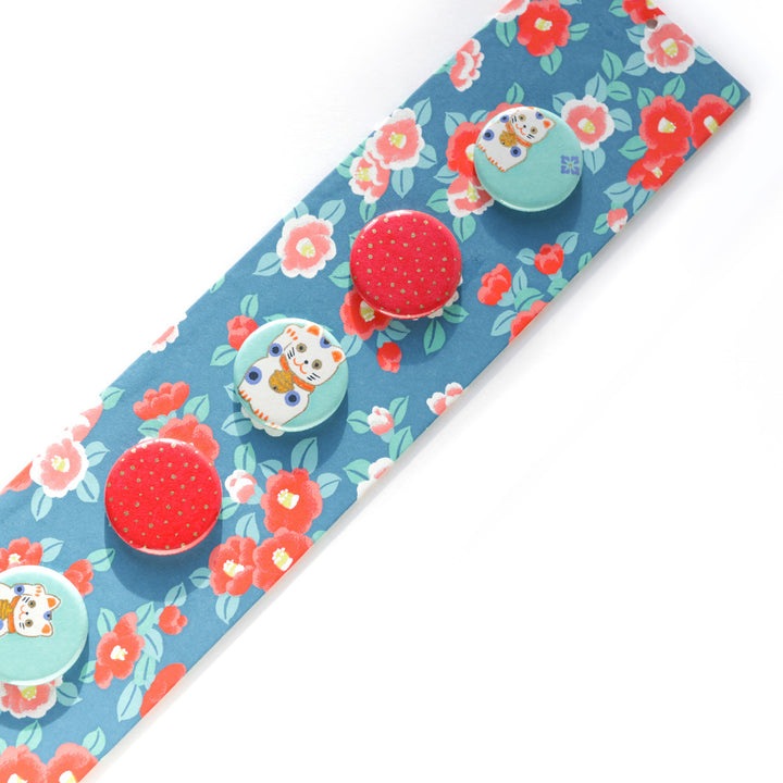 photo packshot avec une vue d'un détail du pêle-mêle tapissé du papier japonais aux motifs de camélias dans les tons bleu foncé, rouge orangé, roses et vert d'eau M956 adeline klam