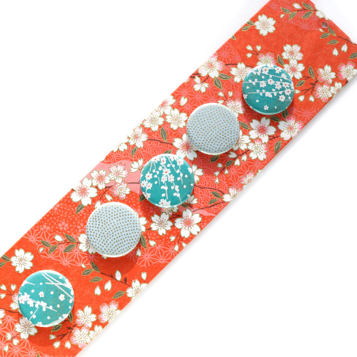 photo packshot avec une vue d'un détail du pêle-mêle tapissé du papier japonais aux motifs de fleurs de cerisier et de dessins variés blanc crème, rose clair et rouge orangé M385 adeline klam