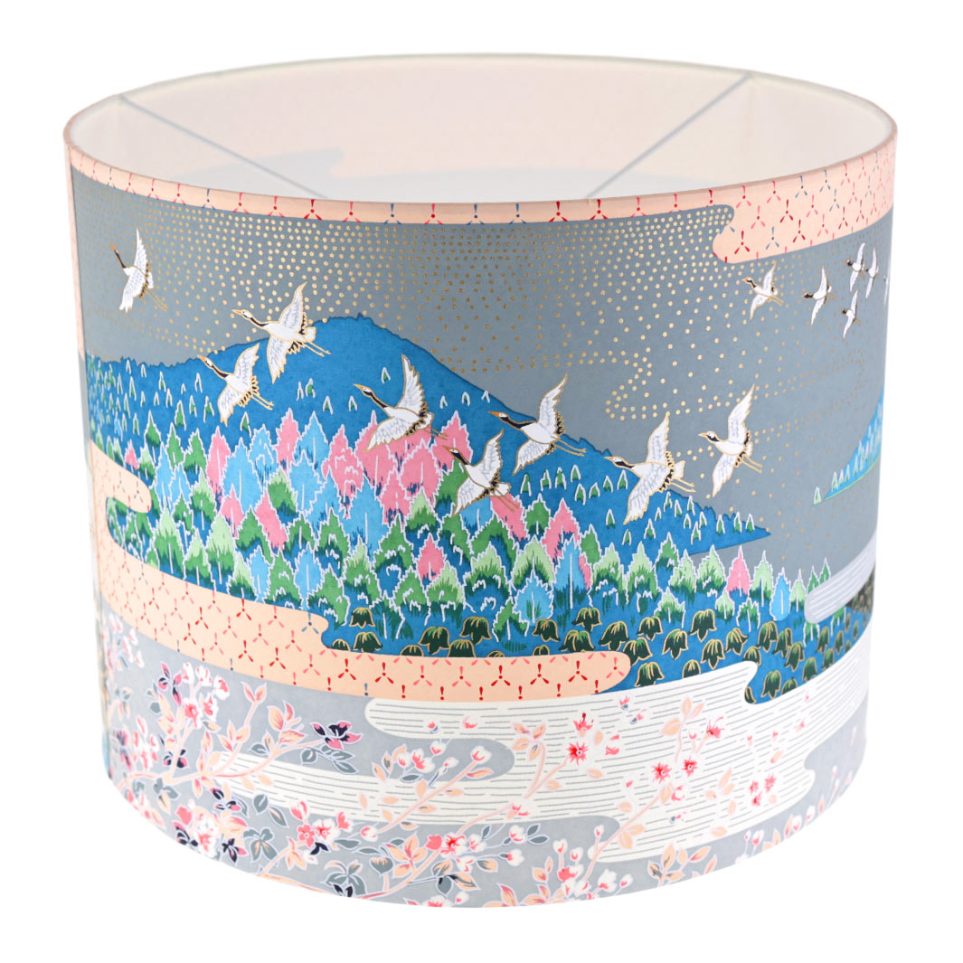 photo packshot avec une vue de face d'un abat-jour japonais au motif de paysage japonais (ciel et montagne) dans les tons bleus, verts, gris, noirs, orange et roses
