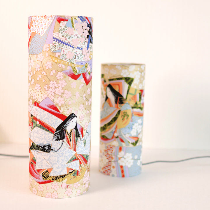 photo packshot avec une vue de face en biais de lampes à poser japonaise (taille s et m) au motif de femmes en kimono dans les tons mordorés, rouges, verts, bleus et mauves
