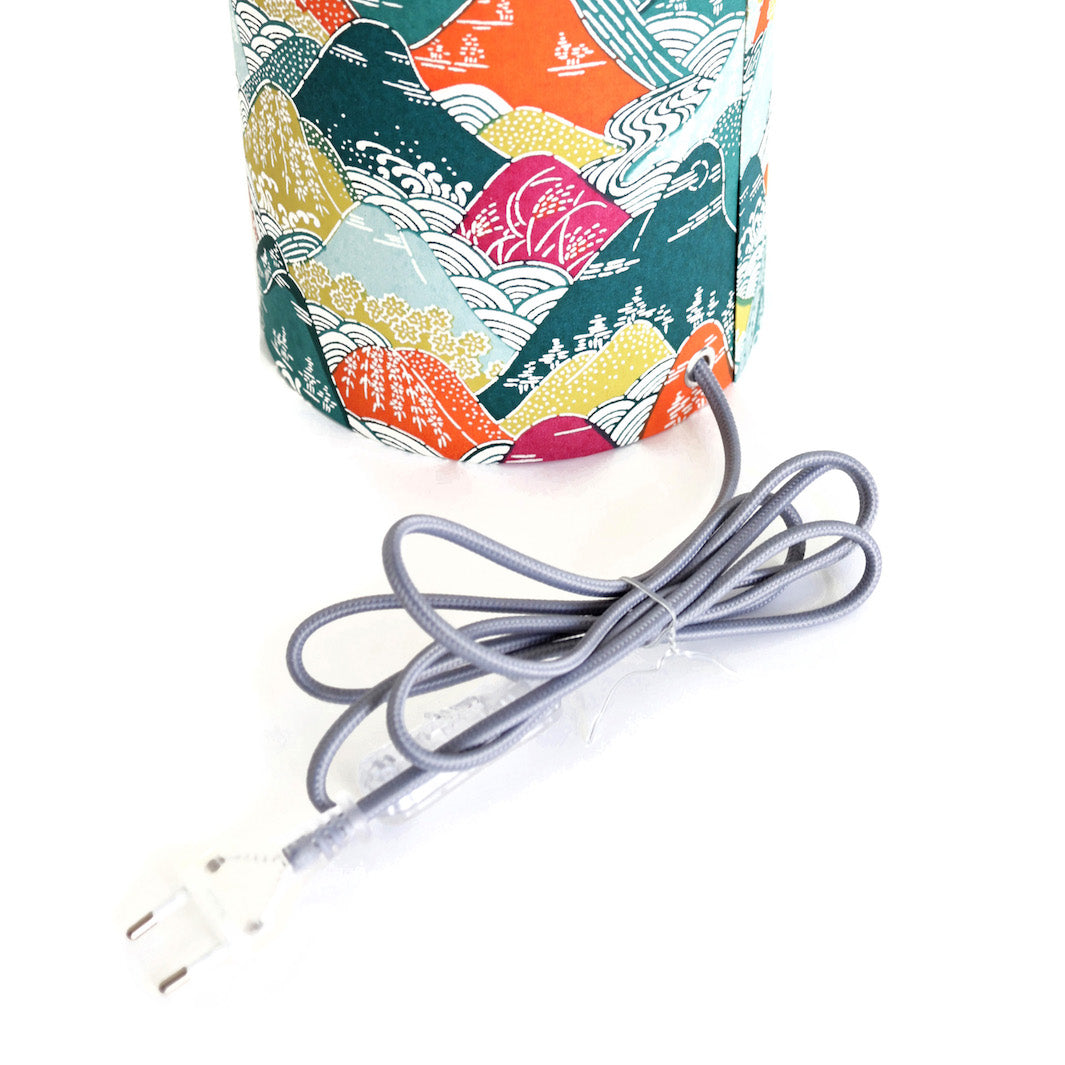 détail d'un câble électrique gris d'une lampe japonaise à poser aux motifs de montagnes et de rivières dans les tons verts, orange, mauve et jaunes (M965) adeline klam