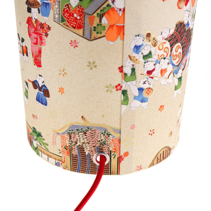 détail du câble électrique rouge de la lampe japonaise à poser aux motifs de scénettes d'un festival japonais dans les tons beiges, rouges, bleus, verts, orange et marrons adeline klam