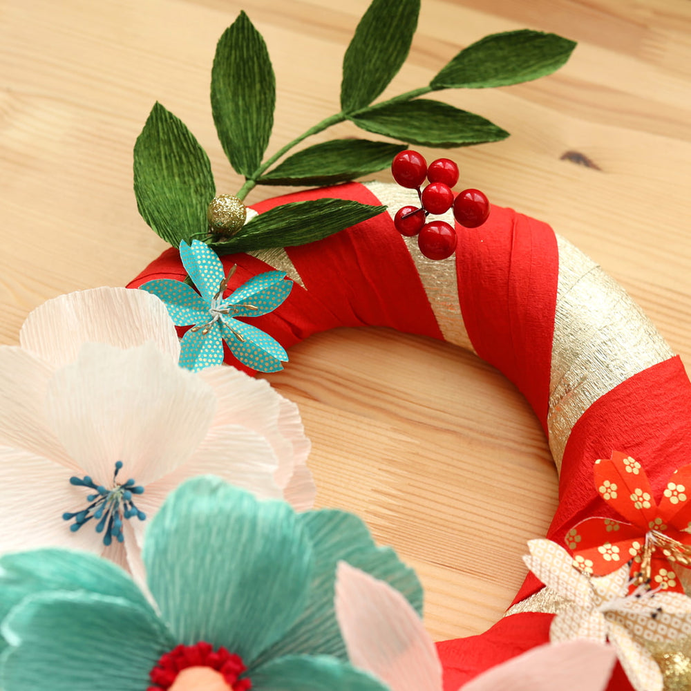 détail de la photo d'ambiance de la couronne de Noël de l'atelier couronne de Noël avec des fleurs en papier crépon 