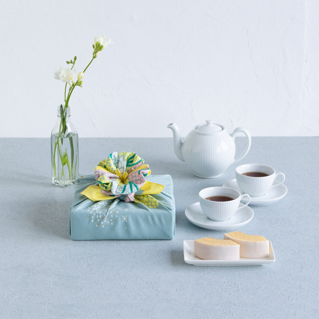 photo packshot d'un emballage cadeau réalisé avec le furoshiki au motif de forêt étoilée dans les tons jaune acidulé, vert de gris et roses adeline x musubi en 70cm par 70cm
