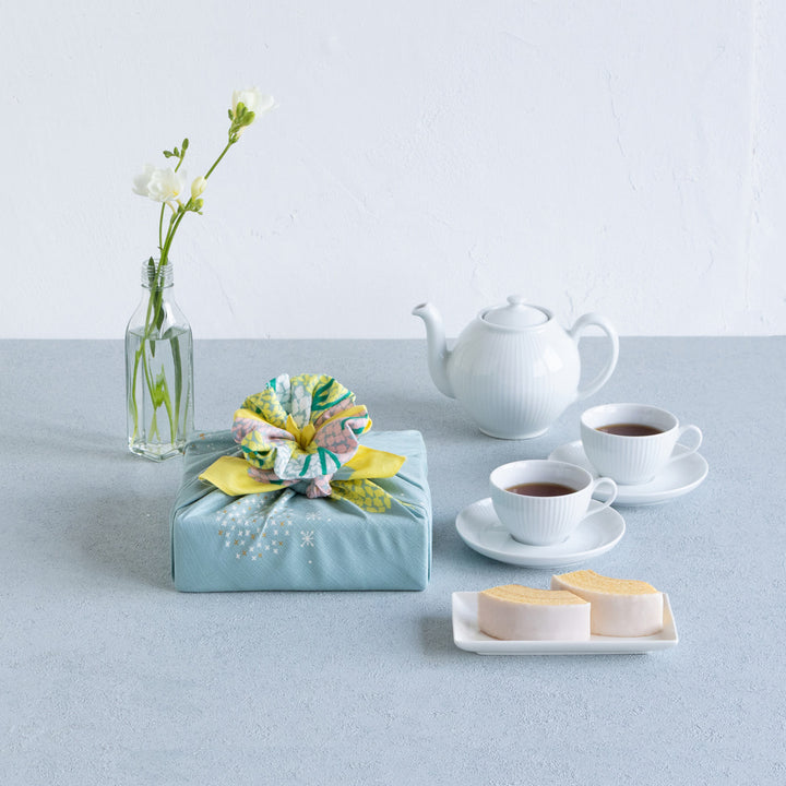 photo packshot d'un emballage cadeau réalisé avec le furoshiki au motif de forêt étoilée dans les tons jaune acidulé, vert de gris et roses adeline x musubi en 70cm par 70cm