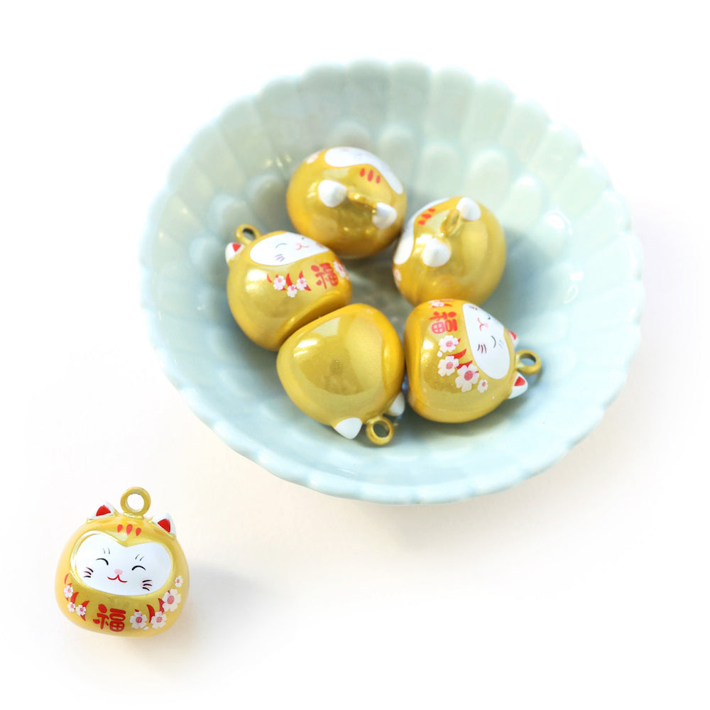 photo d'ambiance de gros grelots en forme de daruma chat jaune nacré