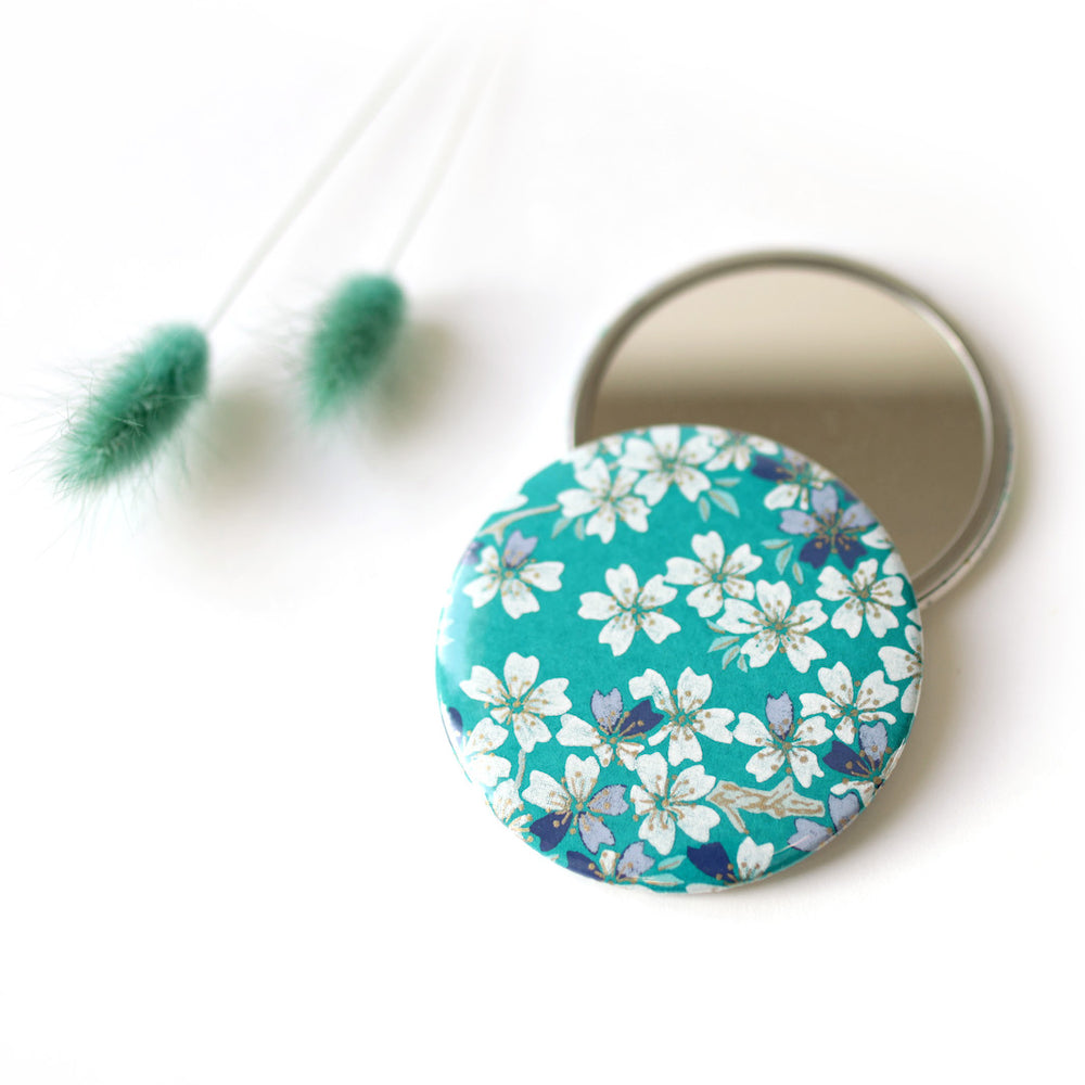 photo d'ambiance du miroir de poche tapissé de papier japonais aux motifs de fleurs de cerisier dans les tons bleu turquoise, bleu marine, gris violet et blanc M625 adeline klam