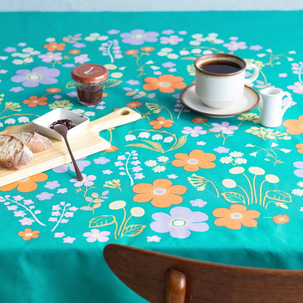 photo d'ambiance d'une table réalisée avec le furoshiki « jardin » dans les tons vert canard, jaunes, violet lilas et orange adeline x musubi en 100cm par 100cm