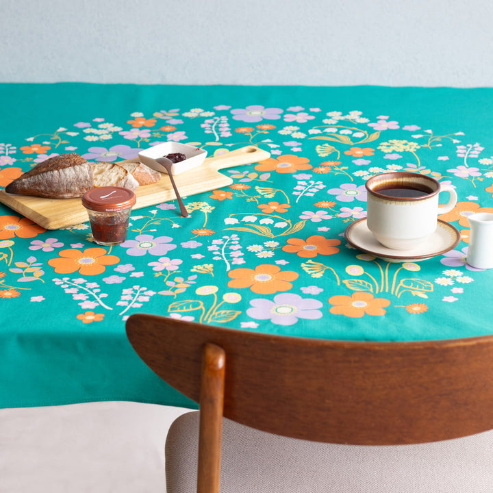 photo d'ambiance d'une table réalisée avec le furoshiki « jardin » dans les tons vert canard, jaunes, violet lilas et orange adeline x musubi en 100cm par 100cm