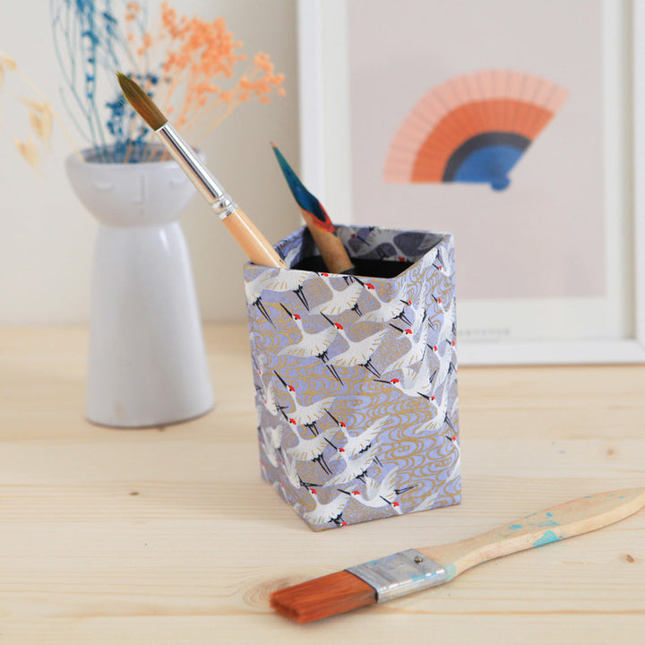 photo d'ambiance du pot à crayon prisme habillé d'un papier japonais aux motifs d'envolée de grues blanches sur fond bleu gris lavande adeline klam (M388)