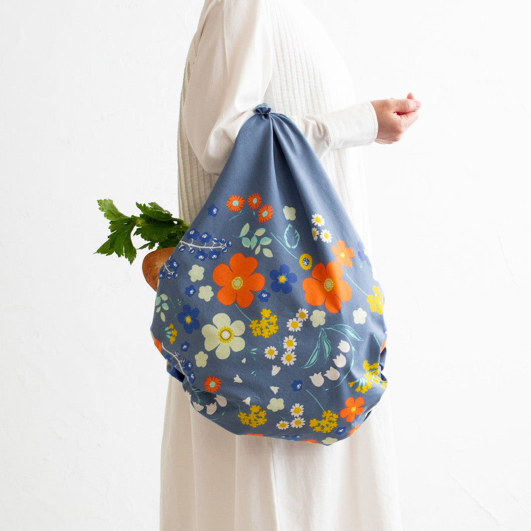 photo d'ambiance d'un sac réalisé avec le furoshiki 100x100cm aux motifs garden « orange » dans les tons bleu gris foncé adeline klam x musubi