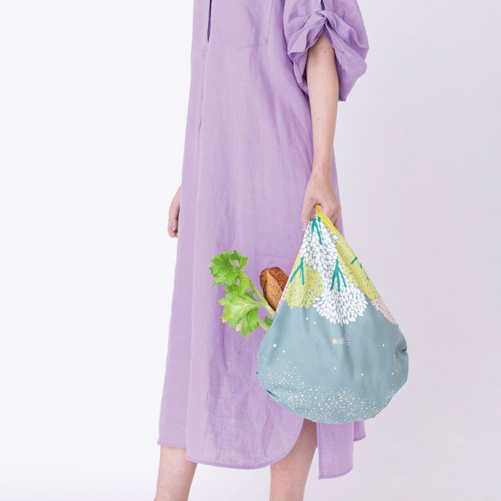 photo packshot d'un sac simple réalisé avec le furoshiki au motif de forêt étoilée dans les tons jaune acidulé, vert de gris et roses adeline x musubi en 70cm par 70cm