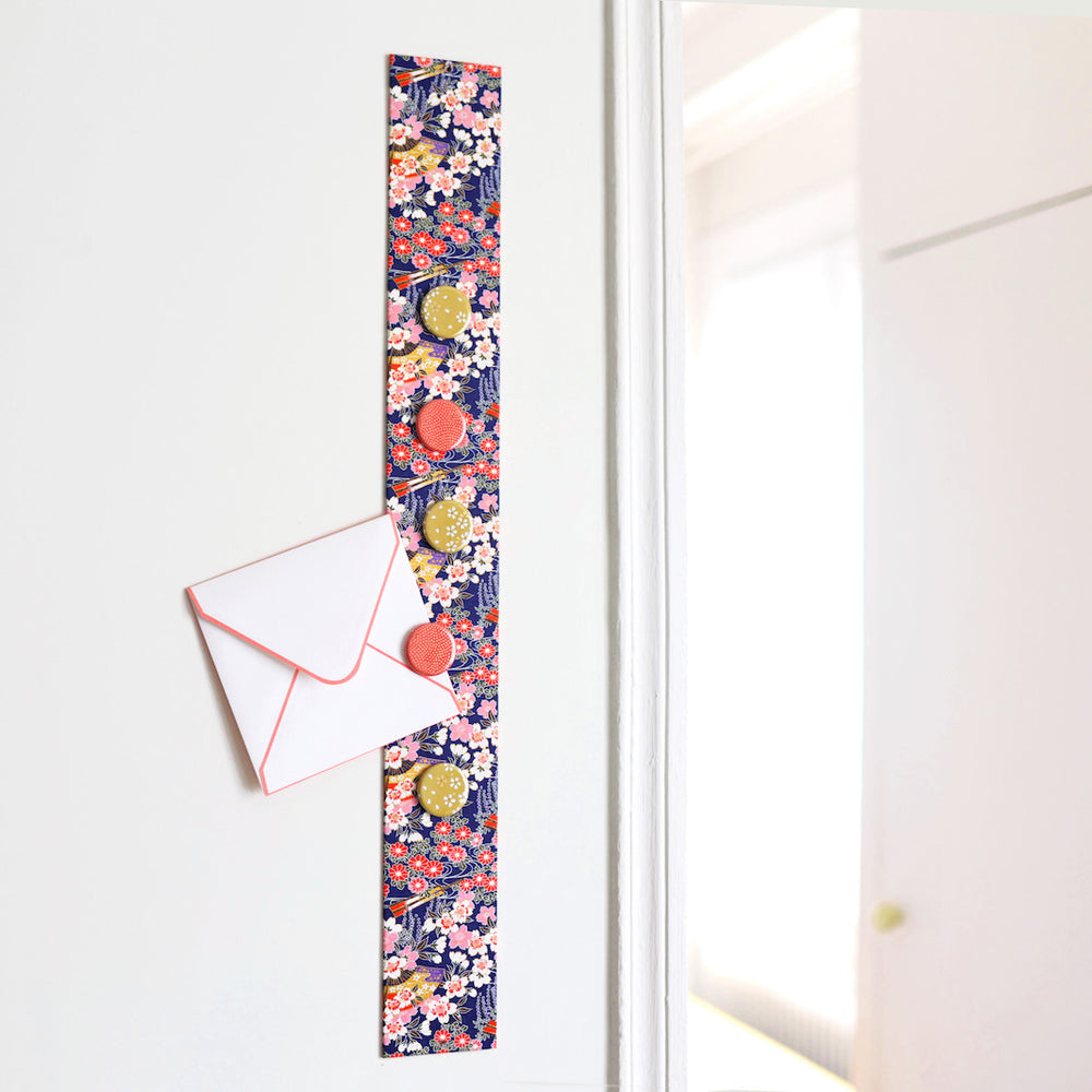 photo d'ambiance avec une vue d'ensemble du pêle-mêle tapissé du papier japonais aux motifs de fleurs de cerisier, de chrysanthèmes, de glycines et d'éventails dans les tons violets, roses, blancs et rouges M908 adeline klam