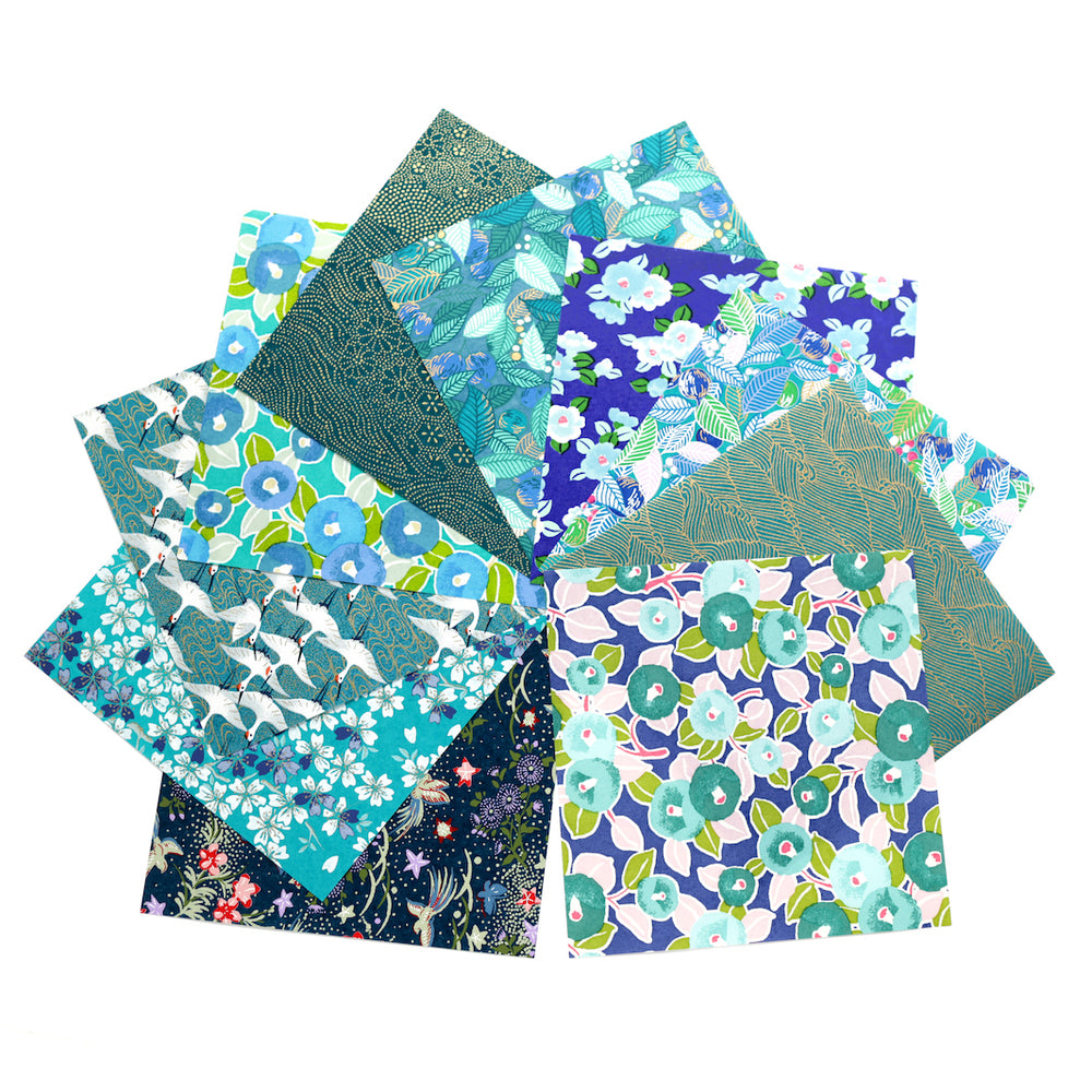 photo packshot de l'assortiment de papiers japonais du set de 7 carrés de papiers japonais adeline klam de 15cm par 15cm dans les tons bleu canard, vert d'eau, bleu nuit, turquoise et violets « paon »