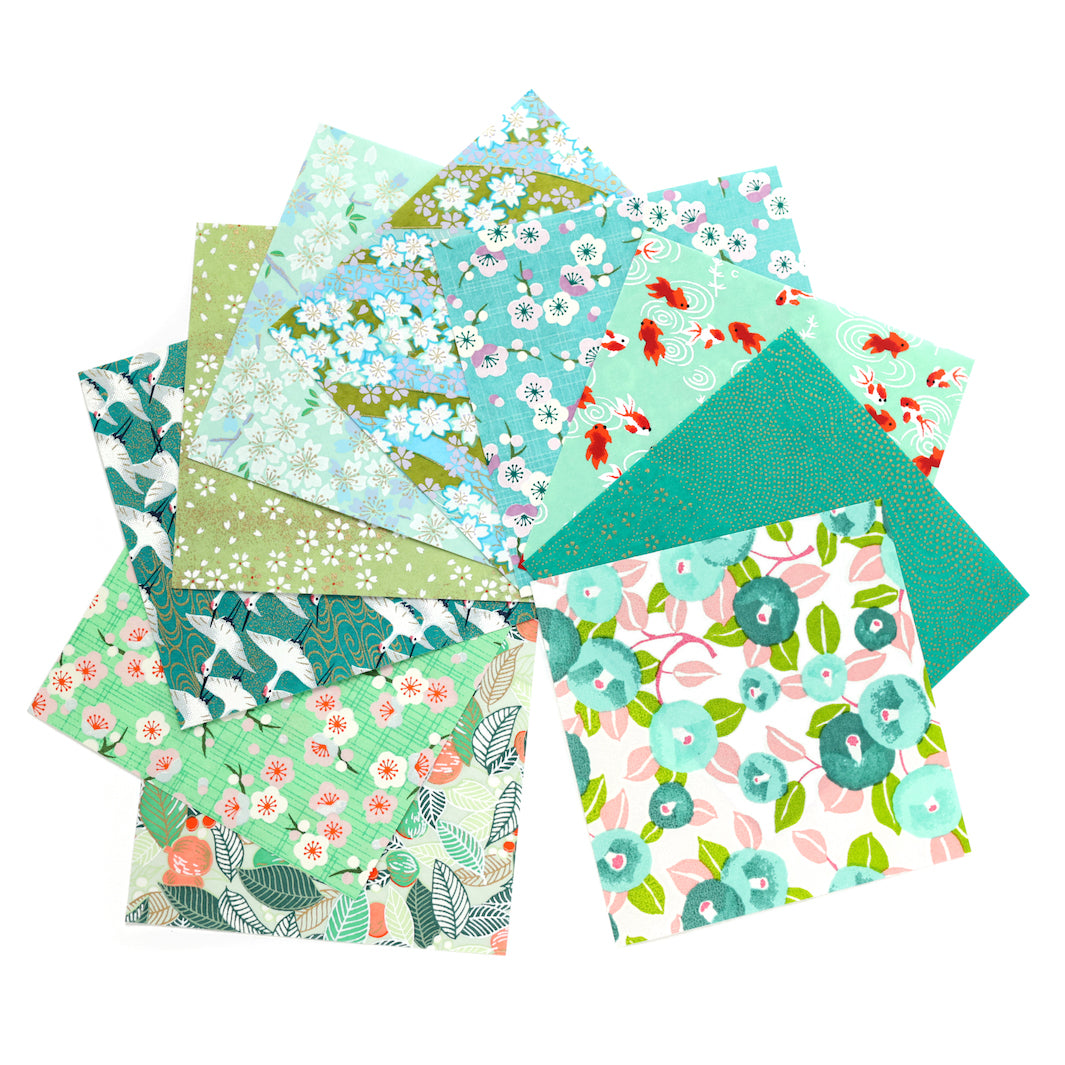 photo packshot de l'assortiment de papiers japonais du set de 7 carrés de papiers japonais adeline klam de 15cm par 15cm dans les tons vert clair et foncé, vert d'eau et menthe et bleu turquoise « garden »