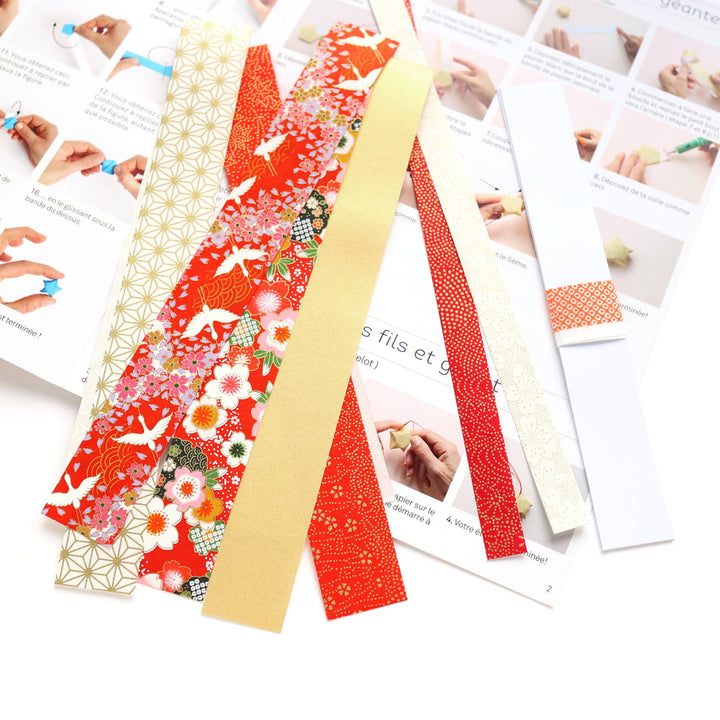 photo packshot des bandelttes de papier japonais et du livret explicatif du kit étoiles à suspendre dans les tons rouge orange, blancs et doré « rubis » adeline klam