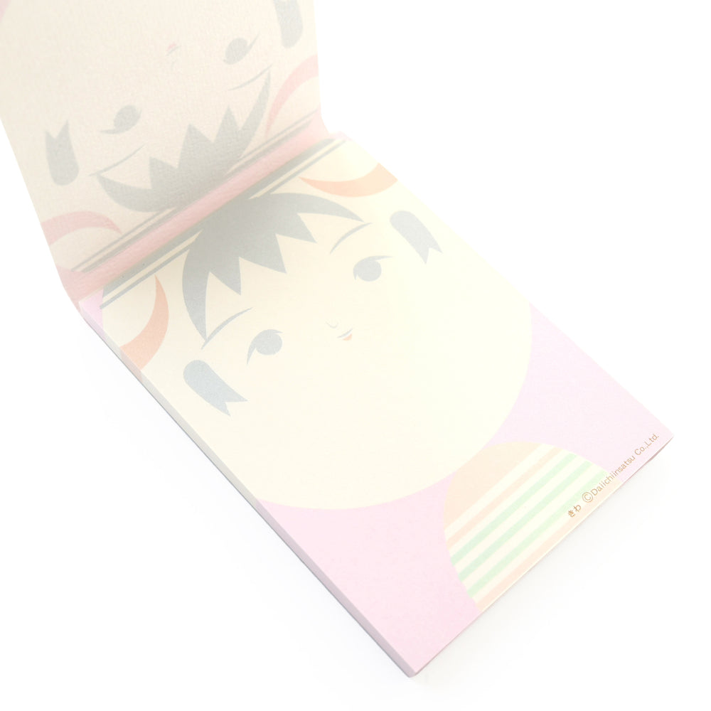 photo packshot de biais de l'intérieur du bloc-notes de 60 feuilles aux motifs de kokeshi sur fond rose