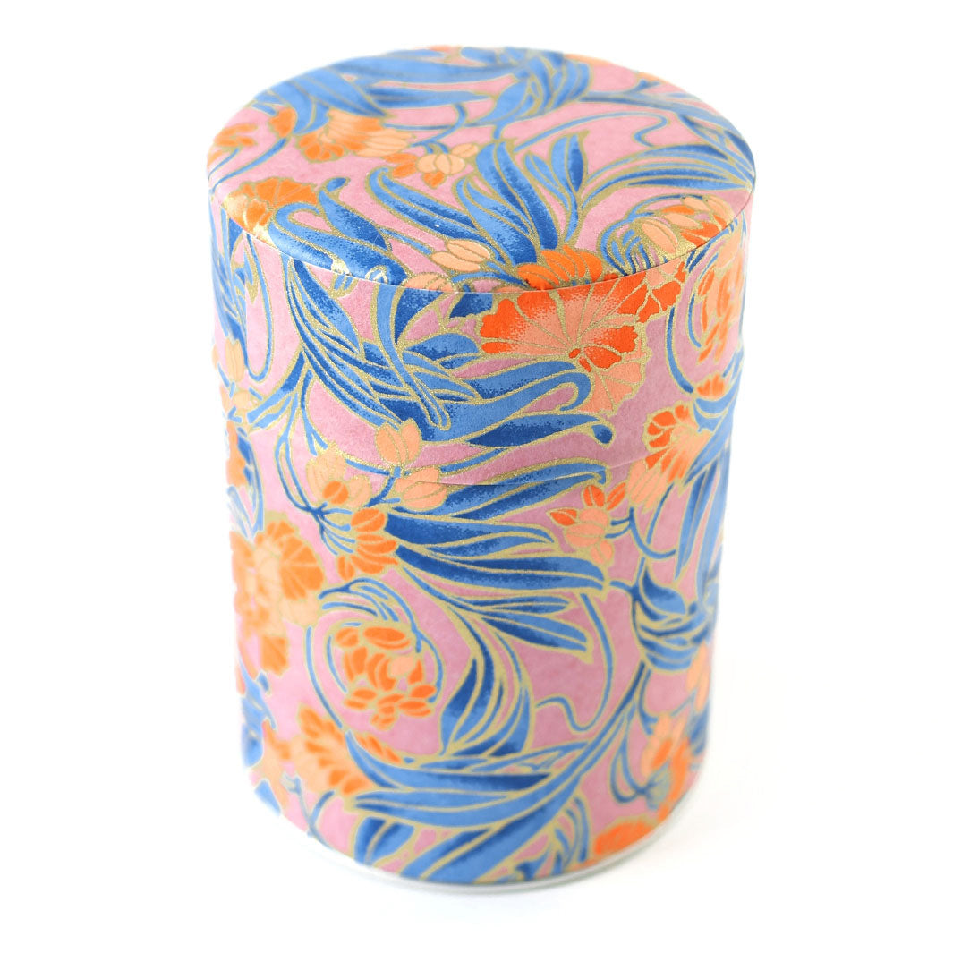 photo packshot d'une boîte à thé cylindrique fermée tapissée d'un papier japonais aux motifs de fleurs « art nouveau » dans les tons mauve, bleus, corail et dorés (M988) adeline klam