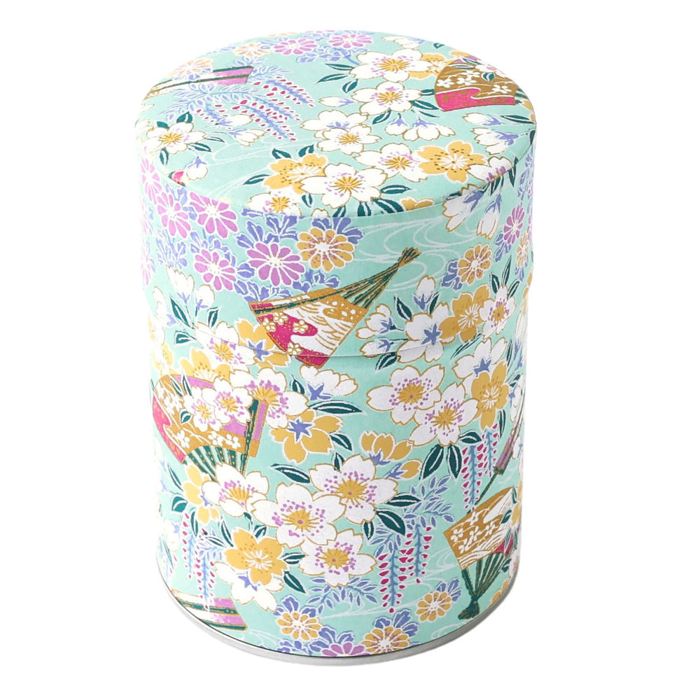 photo packshot d'une boîte à thé cylindrique fermée tapissée d'un papier japonais aux motifs de fleurs de cerisier, de chrysanthèmes, de glycines et d'éventails vert d'eau, jaunes, mauve, parme et blancs (M1017) adeline klam